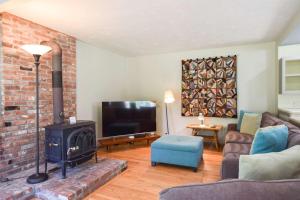 a living room with a fireplace and a tv at Tranquil Cozy Cottage Recently Renovated in Wellfleet