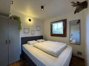 a bedroom with a large bed with a deer head on the wall at Les Trois Feuilles in Petit Mesnil