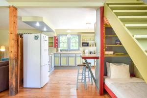a kitchen with a white refrigerator and a staircase at Tranquil Cozy Cottage Recently Renovated in Wellfleet +16 photos
