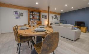 a living room with a table and chairs and a couch at Le charme du moulin in Beauvoir-sur-Sarce