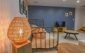 a room with a bed with a lamp in it at Le charme du moulin in Beauvoir-sur-Sarce