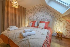 a bedroom with a large bed with towels on it at Le charme du moulin in Beauvoir-sur-Sarce