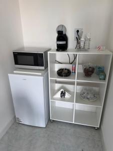 a white cabinet with a microwave and a refrigerator at B&B BLESSED bilocale in Perugia