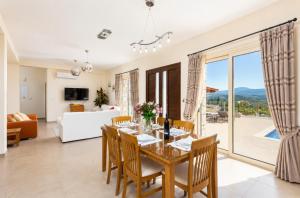 a dining room with a table and chairs and a living room at Villa Christel in Lachi