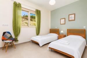 a bedroom with two beds and a chair and a window at Villa Christel in Lachi +32 photos