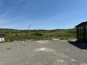 a gravel parking lot with a fence and a field at Green Camp Resort in Hereclean