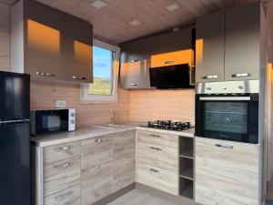 a kitchen with wooden cabinets and a stove top oven at Green Camp Resort in Hereclean