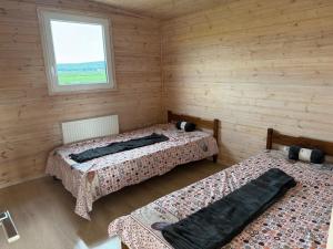 two beds in a wooden room with a window at Green Camp Resort in Hereclean