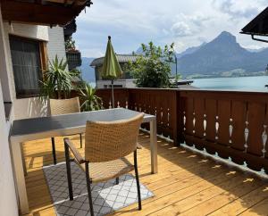 a table and chairs on a balcony with a view of the water at Au 10 in St. Wolfgang