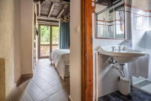 a bathroom with a sink and a bed in a room at Hotel Boutique Santuario Kunturi - Adults Only by Molino de Tresgrandas in Llanes +266 photos
