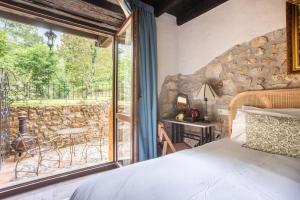 a bedroom with a bed and a large window at Hotel Boutique Santuario Kunturi - Adults Only by Molino de Tresgrandas in Llanes