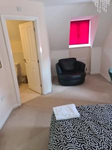 a room with a black chair and a window at Fv Dwelling in Hucknall