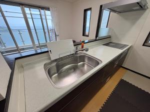 a kitchen with a stainless steel sink in a counter at Outdoor Station 秋谷 in Yokosuka