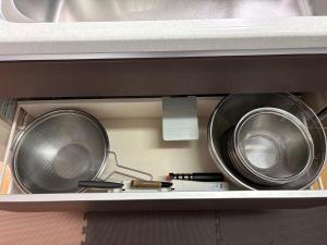 two metal pans are sitting on a shelf at Outdoor Station 秋谷 in Yokosuka +10 photos