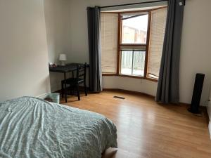 a bedroom with a bed and a desk and a window at HomeNet in Toronto
