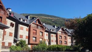 a row of buildings with a mountain in the background at Apartament Vall in Rialp