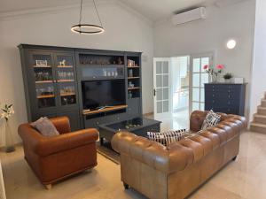 a living room with two couches and a television at Villa Torbellino, Diseño, Privacidad y Confort in La Playa de Tauro