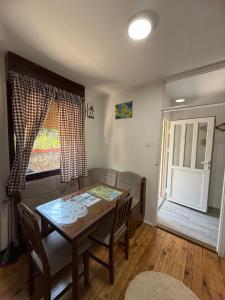 a dining room with a table and chairs and a window at WIN apartment in Plužine