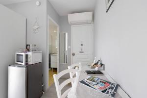 a small kitchen with a table and a microwave at Chambre D'hôtes Le Retour De Plage in Olonne-sur-Mer +10 photos