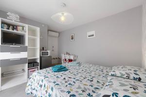 a bedroom with a bed and a television in it at Chambre D'hôtes Le Retour De Plage in Olonne-sur-Mer