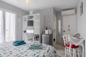 a bedroom with a bed and a table and a kitchen at Chambre D'hôtes Le Retour De Plage in Olonne-sur-Mer