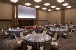 una sala conferenze con tavoli, sedie e uno schermo di Hotel Granvia Hiroshima a Hiroshima