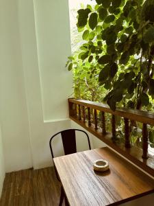 a wooden table and chair in a room with a window at Odi Kamadhoo in Kamadhoo