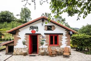 a small house with a red door at Hotel Boutique Santuario Kunturi - Adults Only by Molino de Tresgrandas in Llanes
