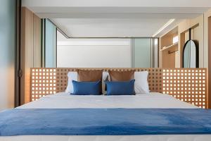 a bedroom with a large bed with blue pillows at Azure Loft: Sea & Luxury in Rio de Janeiro +46 photos