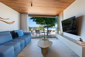 a living room with a blue couch and a tv at Azure Loft: Sea & Luxury in Rio de Janeiro
