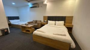 a bedroom with a bed and a couch and a chair at Hotel Marvellen Inn Ltd in Dhaka