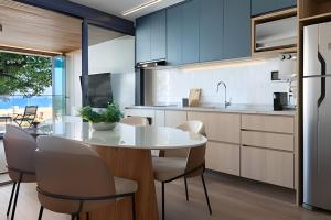 a kitchen with a white table and chairs at Azure Loft: Sea & Luxury in Rio de Janeiro