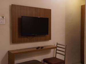 a flat screen tv on a wall in a room at Hotel Trimurti Executive in Dāpuri +9 photos
