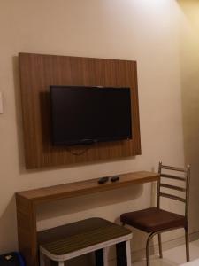 a flat screen tv on a wall with a wooden shelf at Hotel Trimurti Executive in Dāpuri