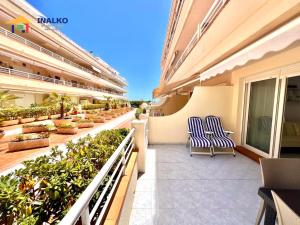 a balcony of a building with two chairs and plants at Cala Montero - Inalko in Alcossebre
