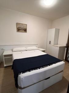 a bedroom with a large white bed with a keyboard at Hostal Cubelles in Cubelles