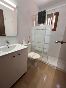 a white bathroom with a toilet and a sink at Hostal Cubelles in Cubelles +25 photos