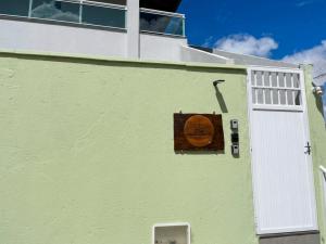 a white building with a sign on the side of it at Suítes Paraíso Perfeito in Flecheiras