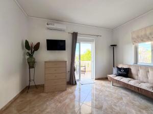 ein Wohnzimmer mit Sofa und Fernseher in der Unterkunft Serenity house in Souda