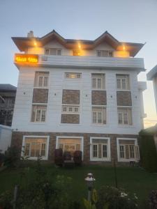 a large white building with a sign on it at Vakil Villa in Srinagar