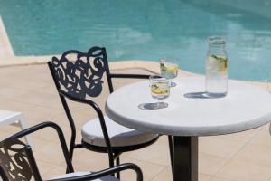 Ein Tisch und Stühle mit Getränken darauf neben einem Pool in der Unterkunft Maryan in Limenas