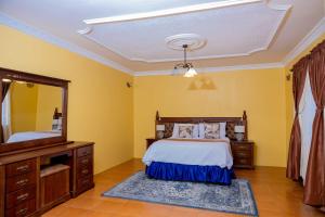 a bedroom with a bed and a large mirror at Mainway home in Harare