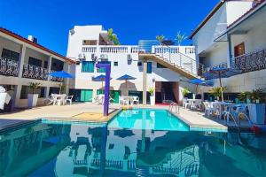 a swimming pool in front of a building at Happy Hotel Ancoradouro in Porto Seguro