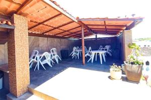 a patio with chairs and a table under a pergola at Happy Hotel Ancoradouro in Porto Seguro +8 photos