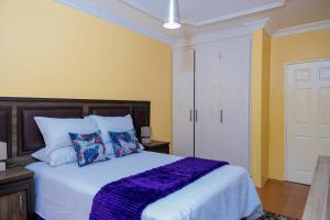 a bedroom with a large white bed with pillows at Mainway home in Harare