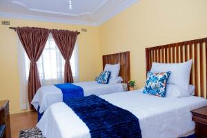 a bedroom with two beds and a window at Mainway home in Harare