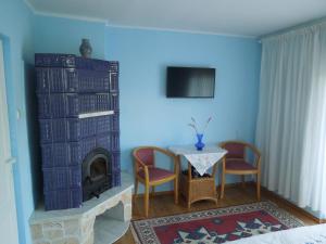 a living room with a table and a fireplace at Casă de oaspeți autentică în Transilvania in Izvoru Mureşului