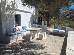 a patio with couches and a table and chairs at Charmante maison cycladique traditionnelle in Faros
