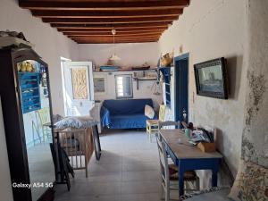 a living room with a table and a blue couch at Charmante maison cycladique traditionnelle in Faros