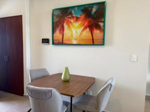 a dining room table with chairs and a painting on the wall at San Francisco Cancun in Cancún